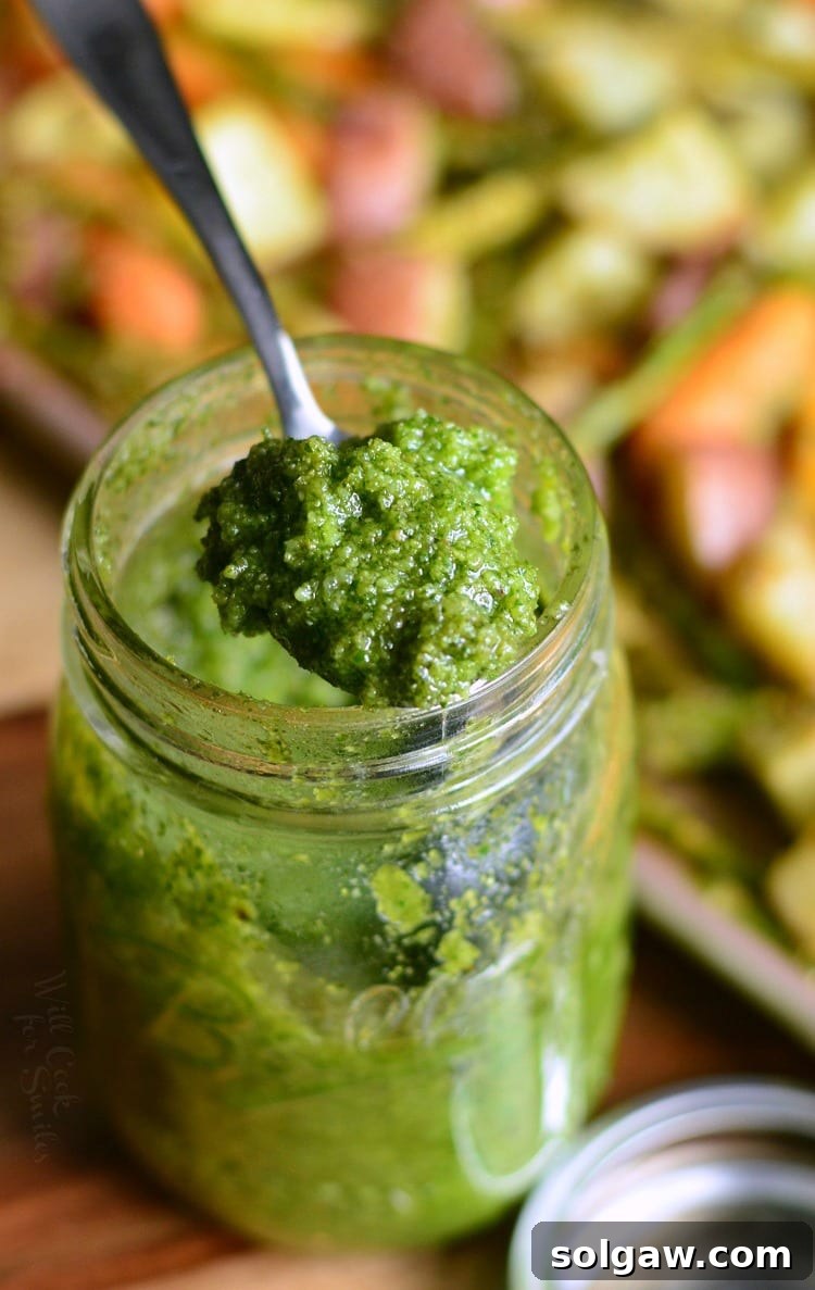 Homemade Pesto with Cashews in a jar with a spoon scooping some out 