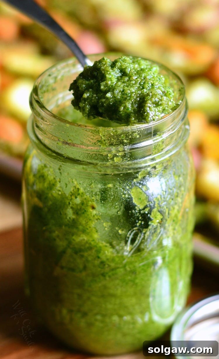 pesto in a jar with a spoon scooping some out 