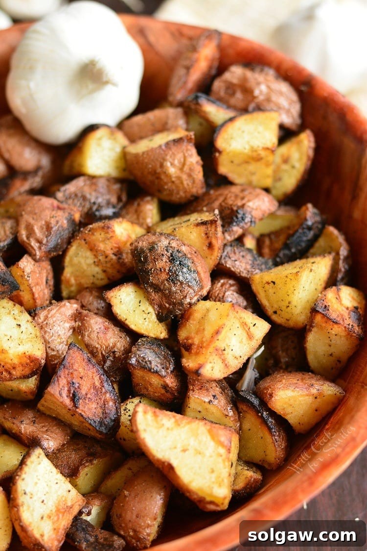 Grill Roasted Garlic Potatoes in a wood bowl with a bulb of garlic