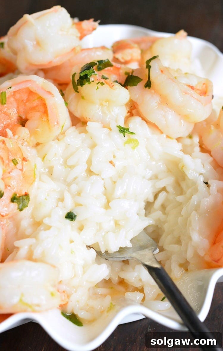 Key Lime Coconut Shrimp and Coconut Rice in a serving bowl with a fork