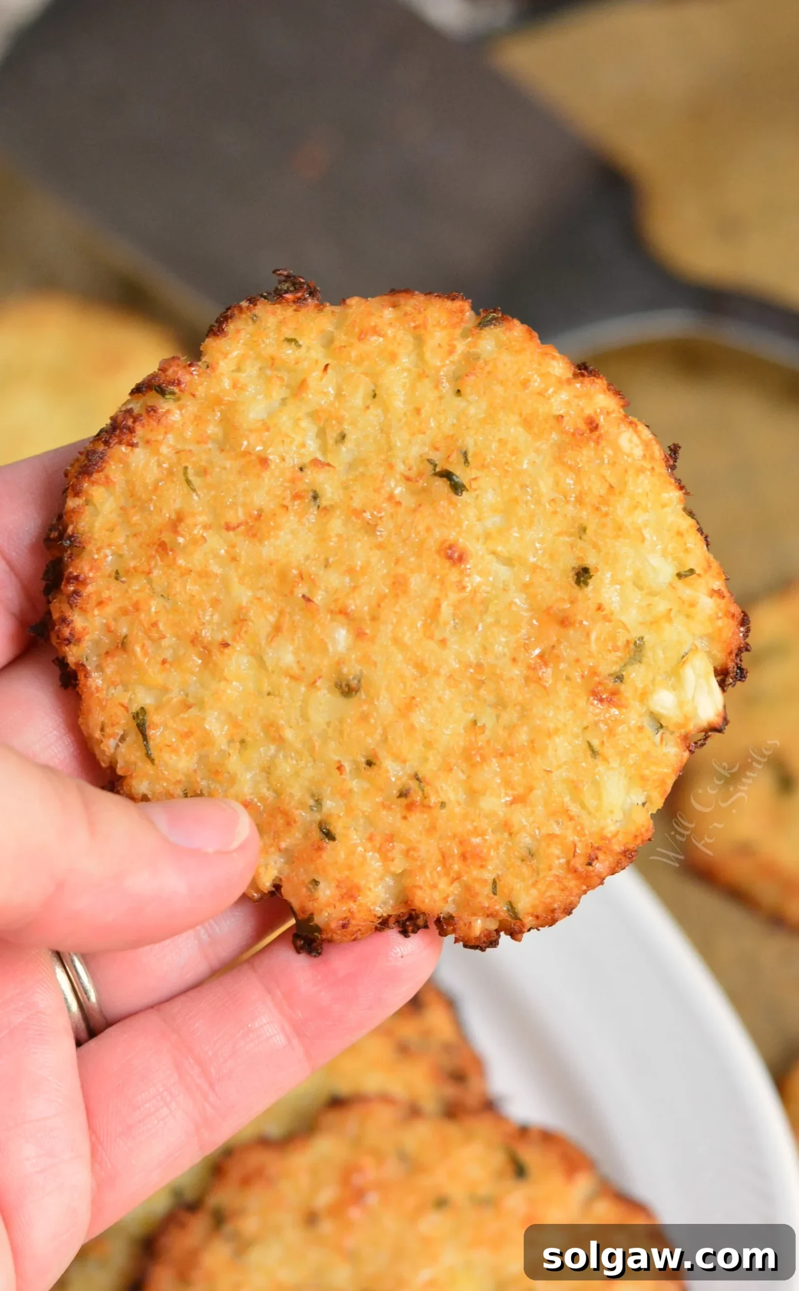 Close-up shot of crispy Cauliflower Parmesan Crisps arranged on a platter, showcasing their golden-brown edges and cheesy texture.