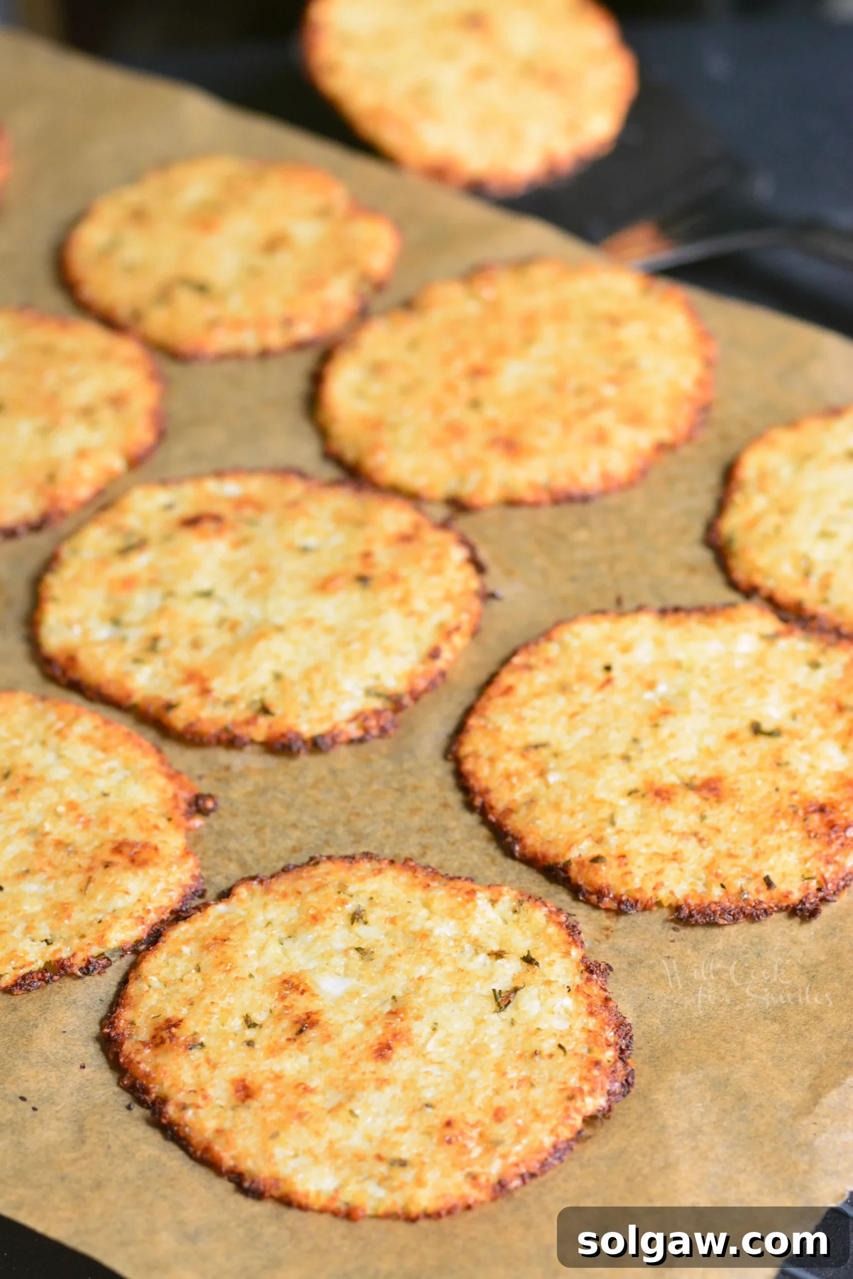 Cauliflower Parmesan Crisps cooling on a baking sheet, ready to be enjoyed as a healthy snack.