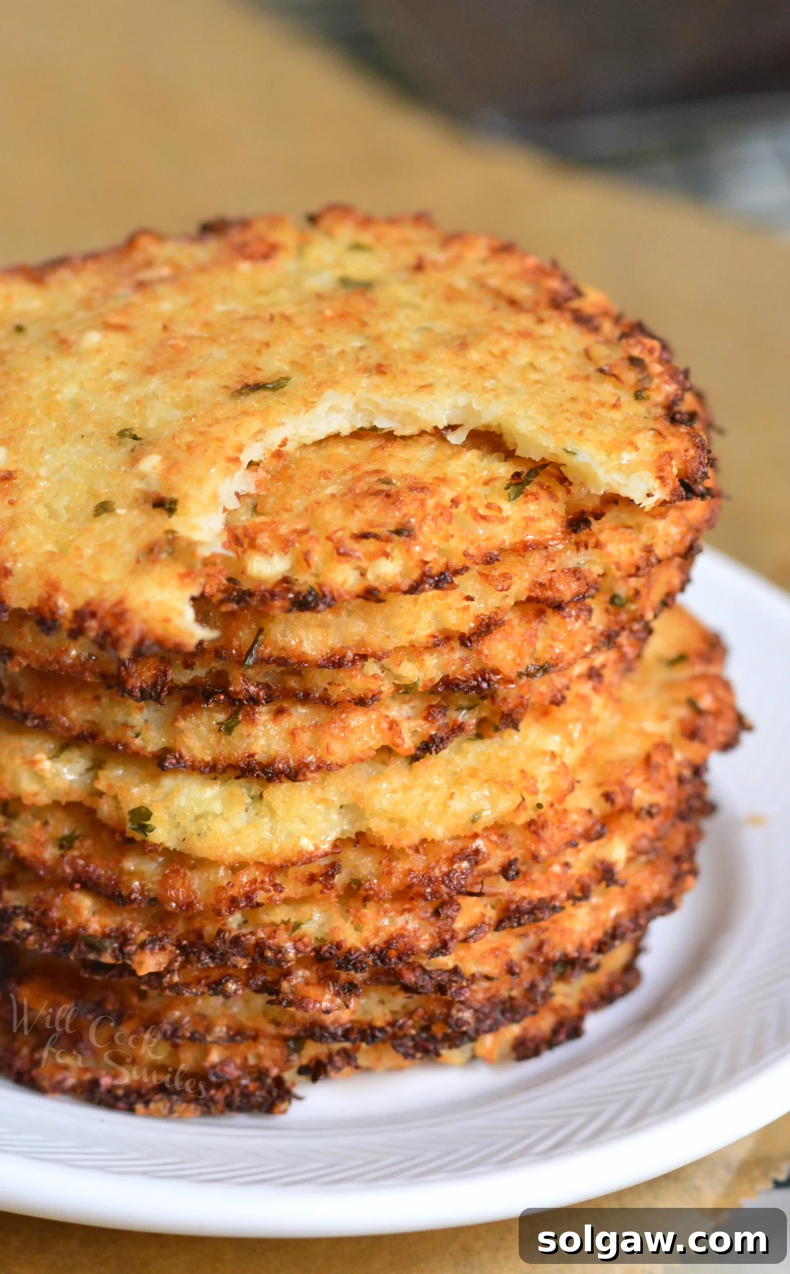 Ingredients for Cauliflower Parmesan Crisps laid out on a cutting board, including fresh cauliflower, block Parmesan, and spices.