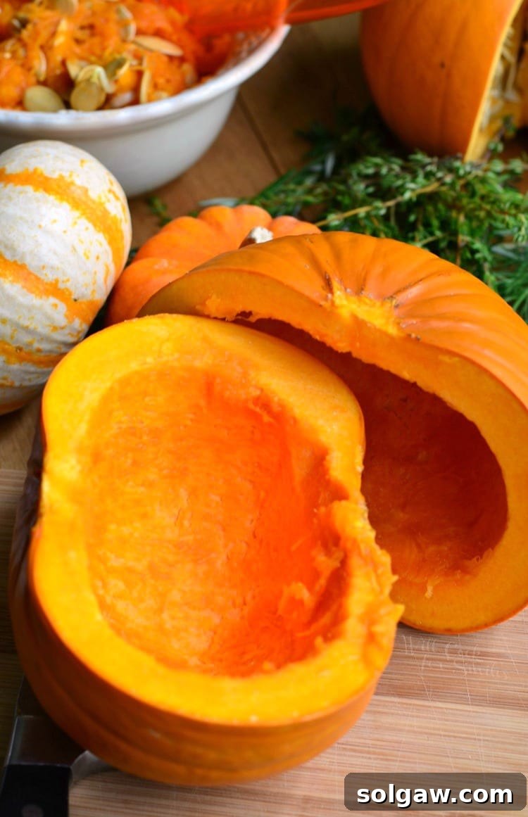 pumpkin cut in half with seeds removed bowl of seeds in the background