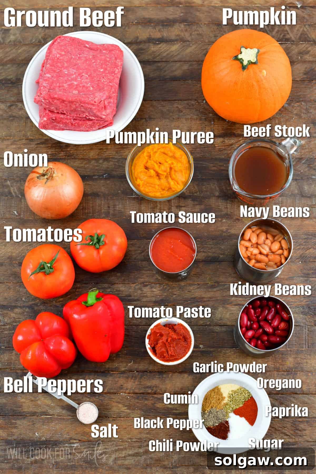 A selection of pumpkin chili ingredients, including fresh pumpkin, canned pumpkin puree, various vegetables, and spices, neatly arranged on a rustic wooden surface.