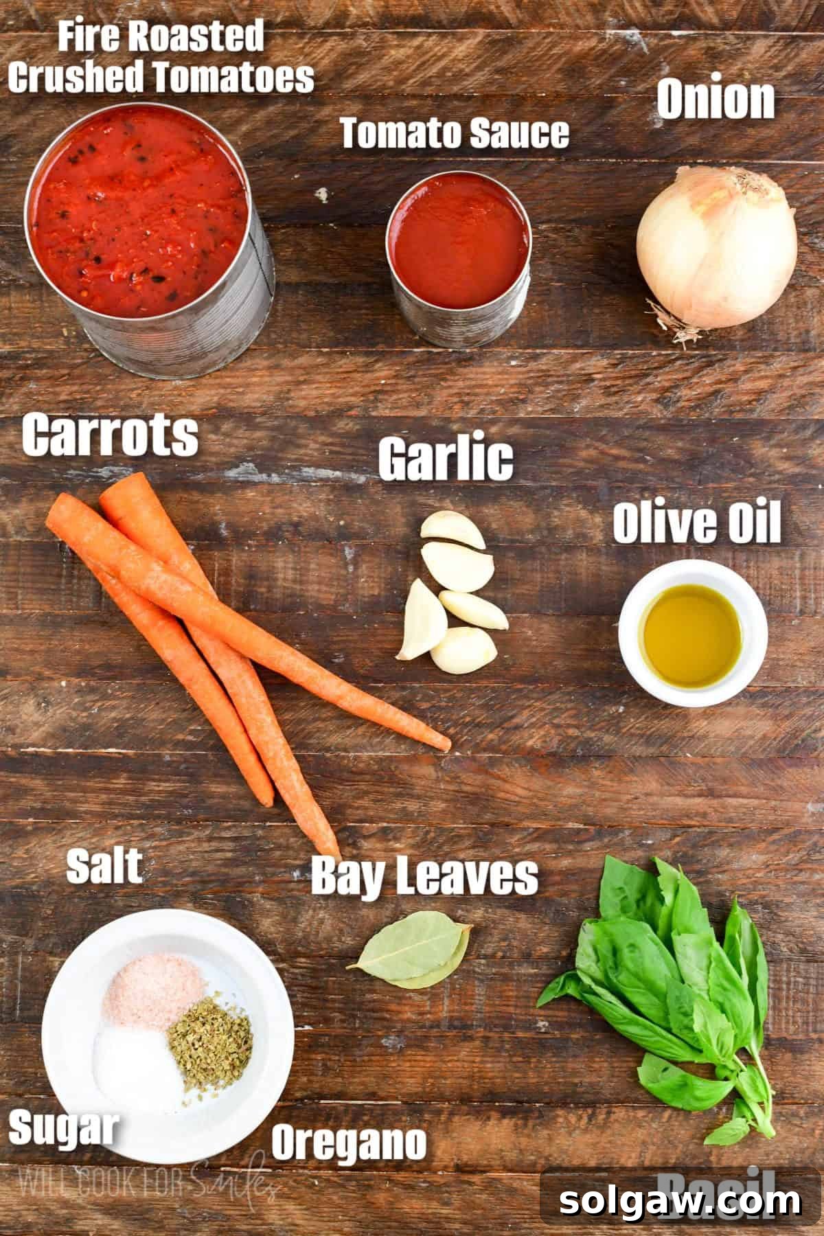 Clearly labeled fresh ingredients for making homemade tomato spaghetti sauce, arranged neatly on a wooden cutting board, ready for preparation.