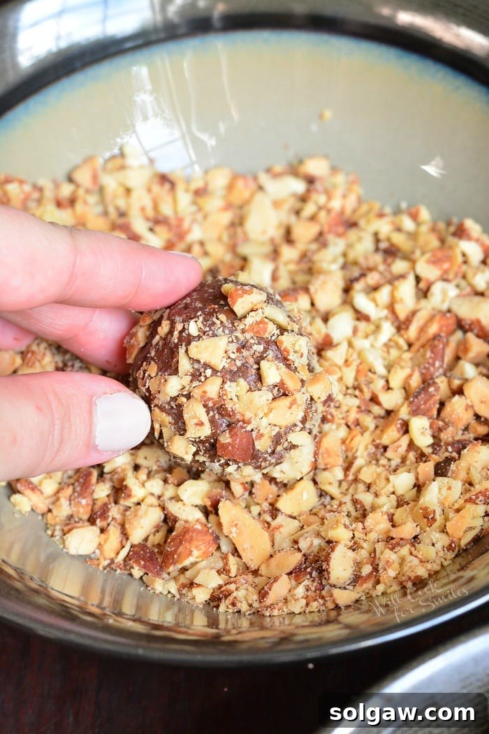 uncooked Nutella Cookies being rolled in nuts 