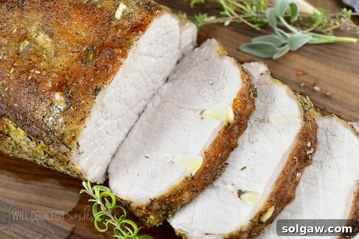 Aromatic Garlic Pork Loin 10 pork loin sliced with garlic visible and herbs.