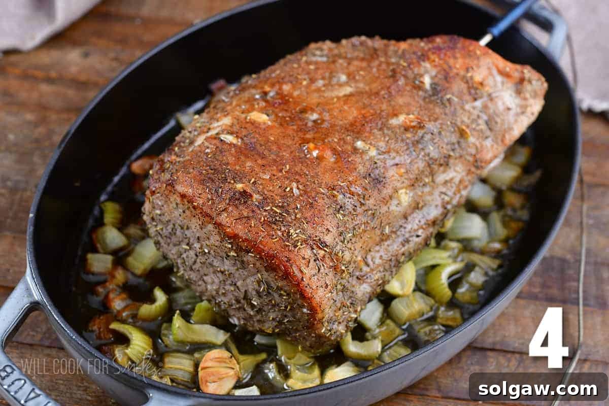 Aromatic Garlic Pork Loin 7 cooked garlic pork loin on veggies in the roasting pan.