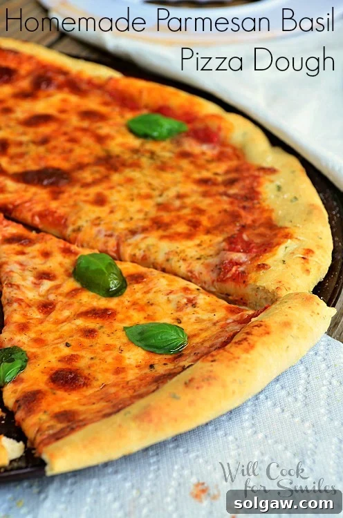 Parmesan Basil Infused Pizza Dough 2 cheese pizza cut into slices on a pizza pan with a napkin under the pan