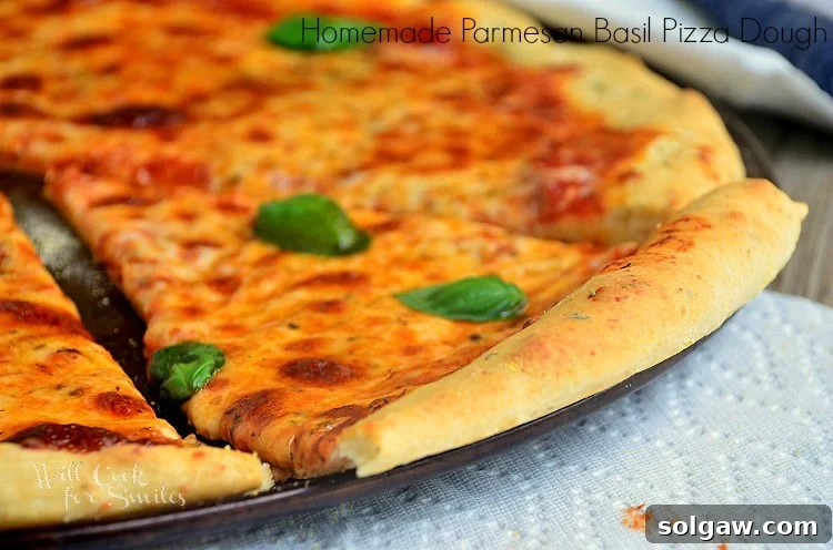 Parmesan Basil Infused Pizza Dough 5 cheese pizza cut into slices on a pizza pan with a napkin under the pan