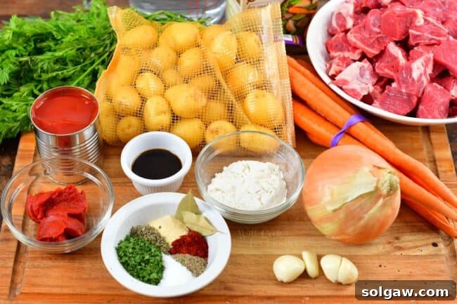Fresh ingredients for beef stew laid out on a cutting board, including beef, carrots, and potatoes