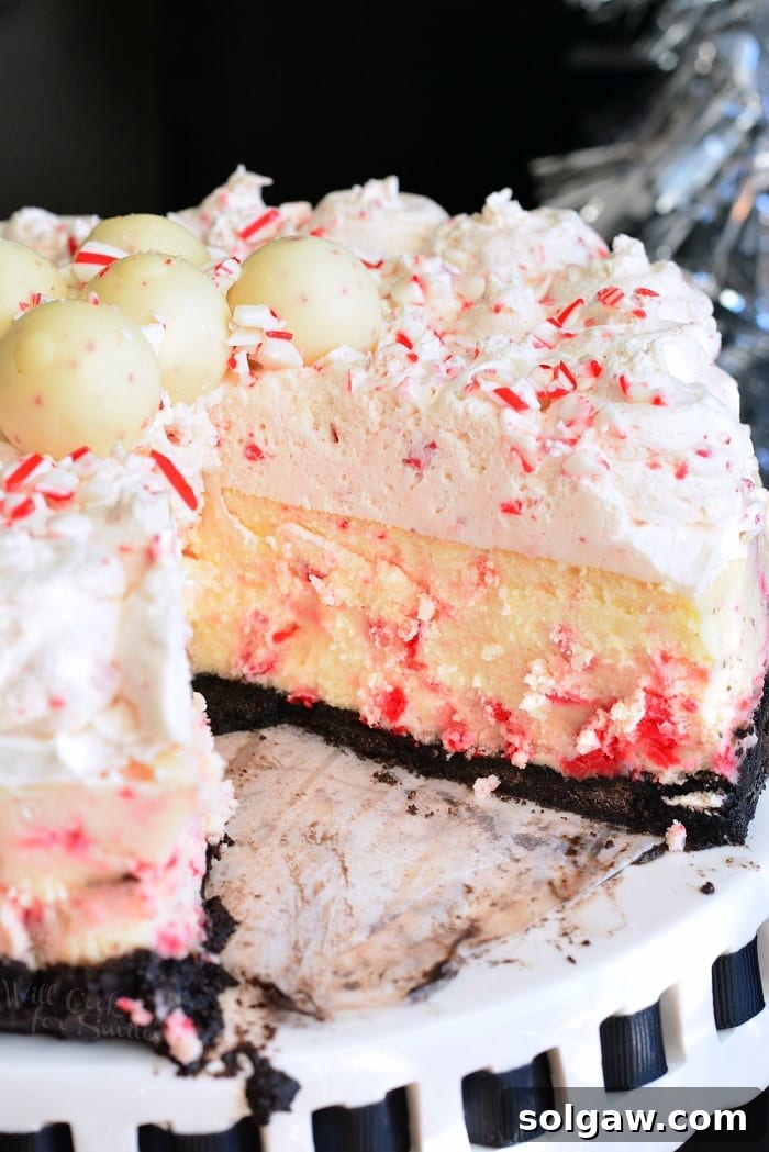 Peppermint Bliss Cheesecake 4 A beautiful slice of Peppermint Cheesecake, showing its creamy texture and festive layers, on a wooden table with candy canes in the background, ready to be enjoyed.
