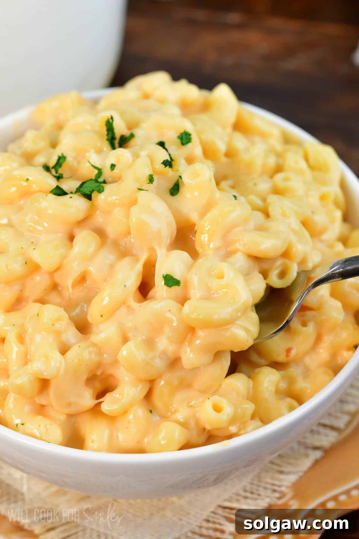 A big bowl full of mac and cheese with a fork scooping some out.