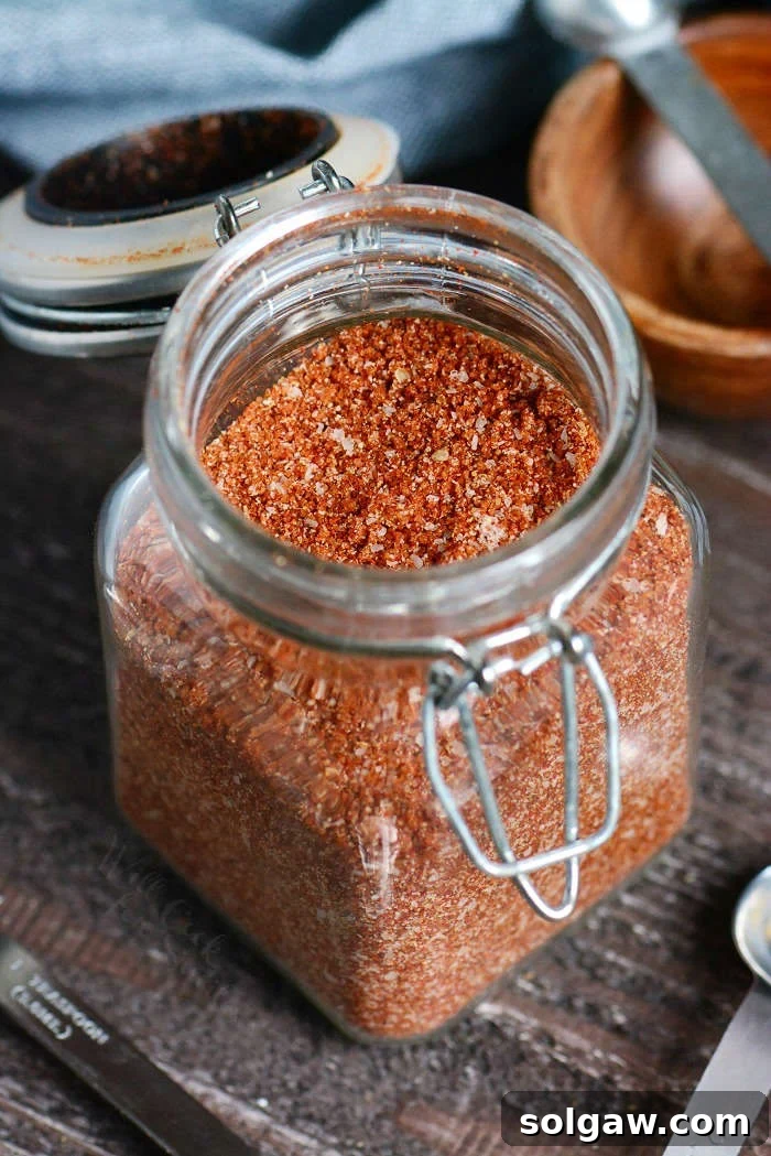 Dry Rub in a glass jar on a wooden cutting board