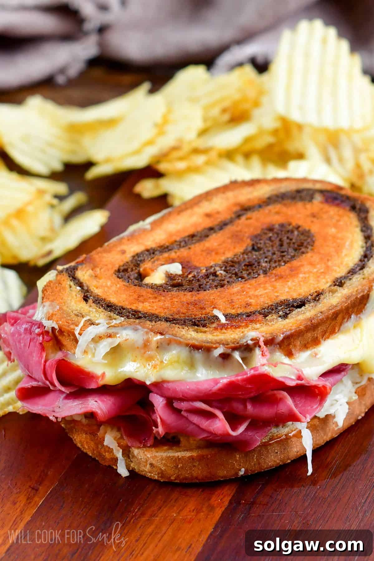Crispy potato chips served next to a delicious, halved Reuben sandwich.