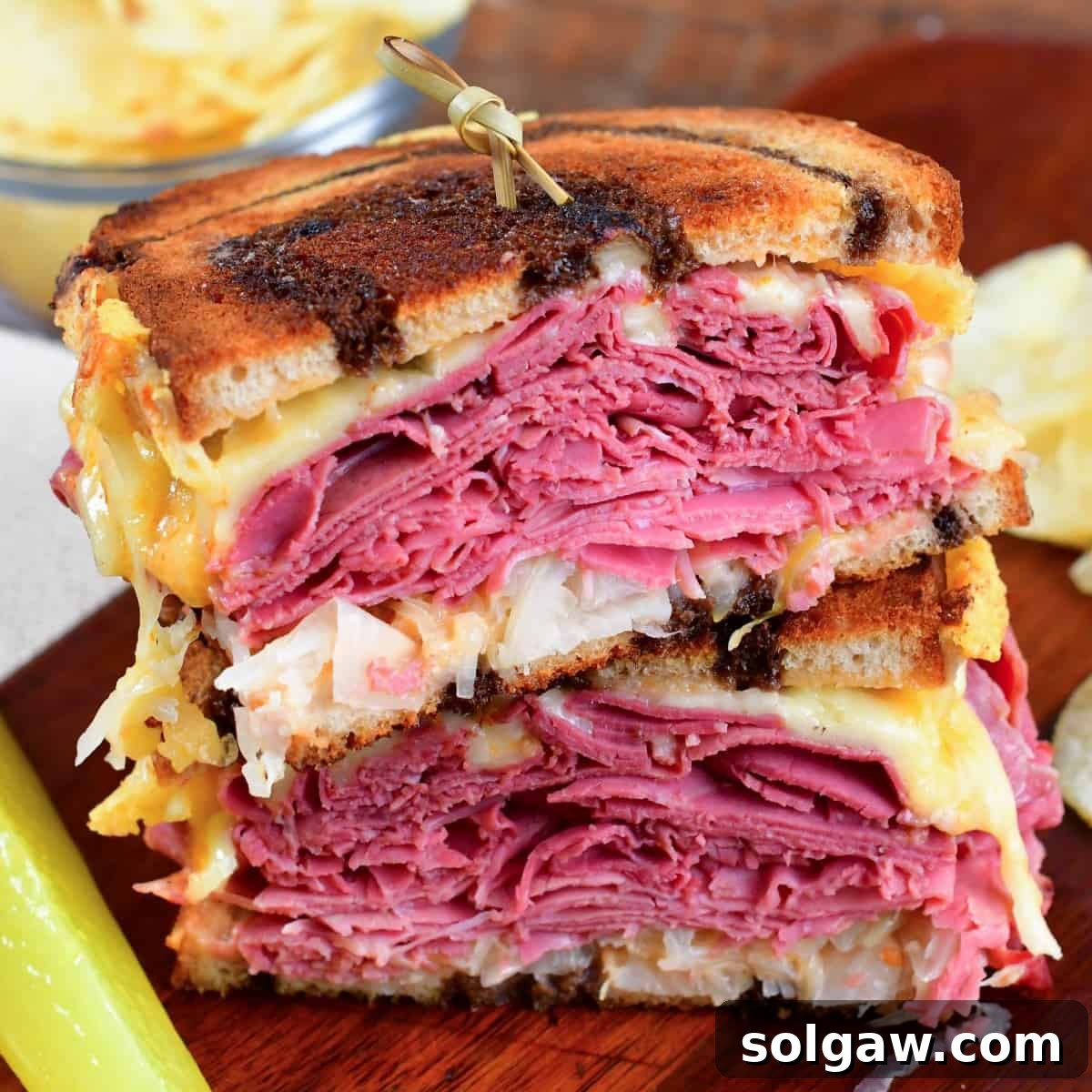 cooked Reuben sandwich halves stacked on top of each other.