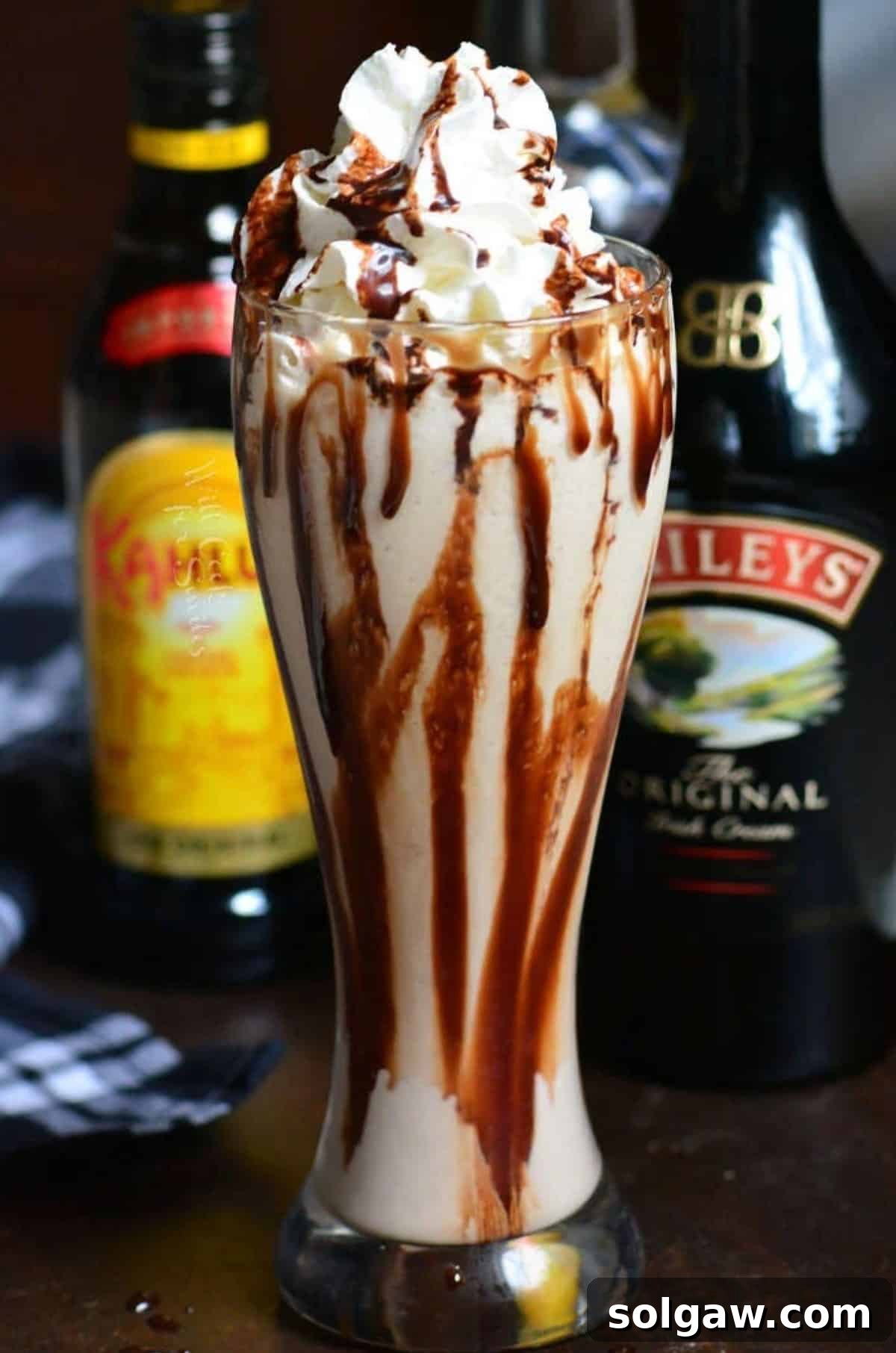 Fork in the Torrent 2 Frozen Mudslide cocktail blended in a tall glass with whipped cream and chocolate drizzle, perfect for a decadent dessert drink.