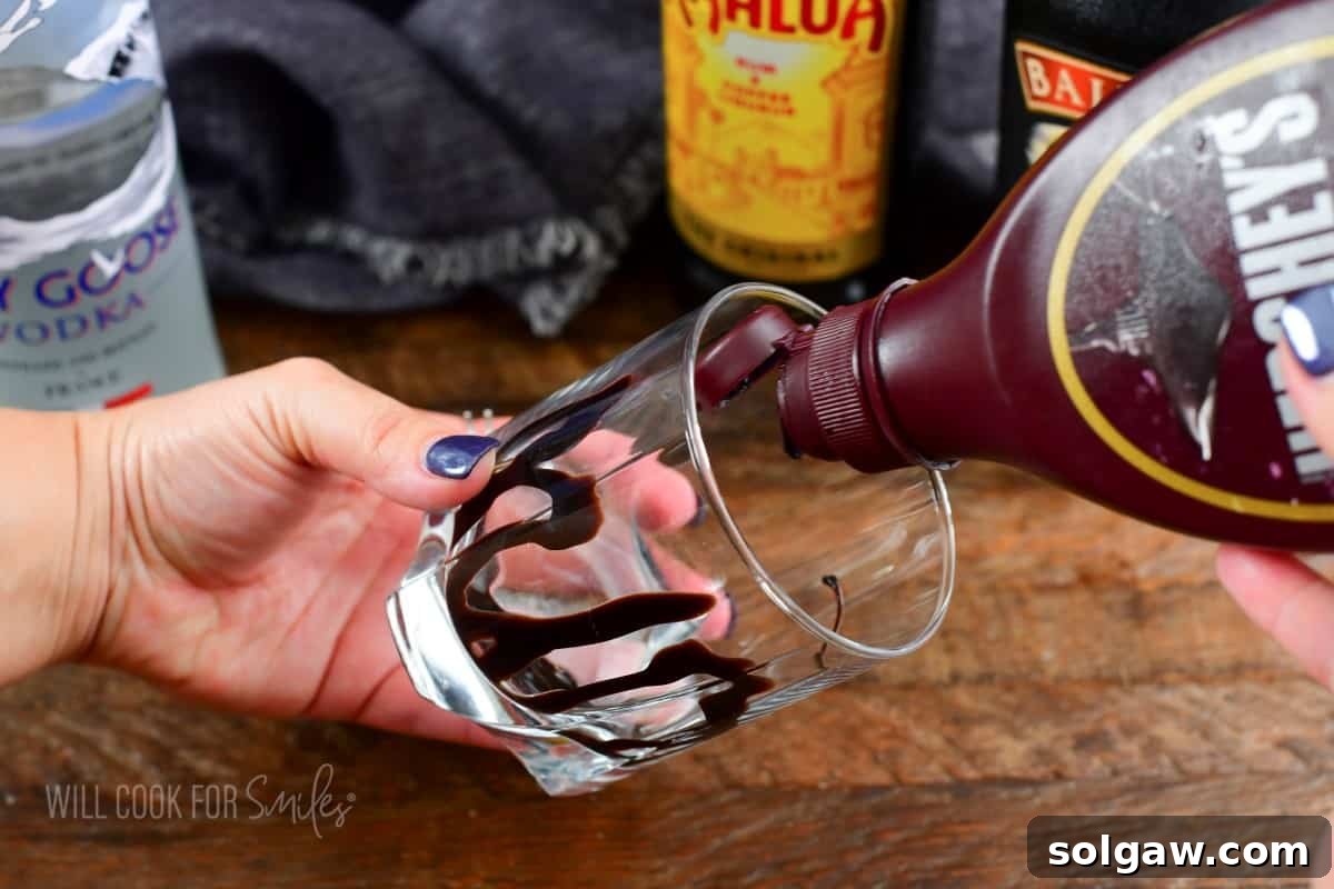 Fork in the Torrent 5 Drizzling chocolate syrup expertly into a rocks glass to decorate it before pouring the cocktail.
