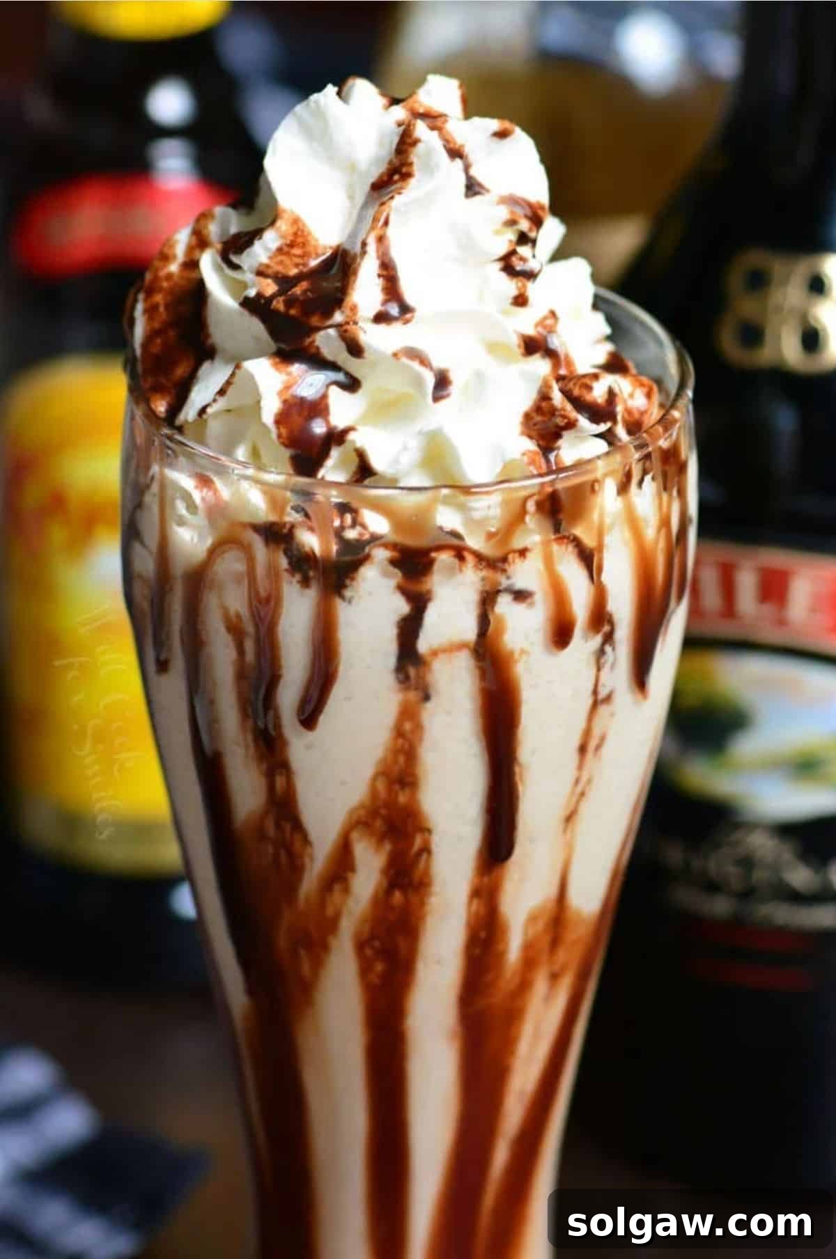 Fork in the Torrent 7 Frozen Mudslide cocktail in a tall glass, garnished with chocolate syrup and a generous dollop of whipped cream.