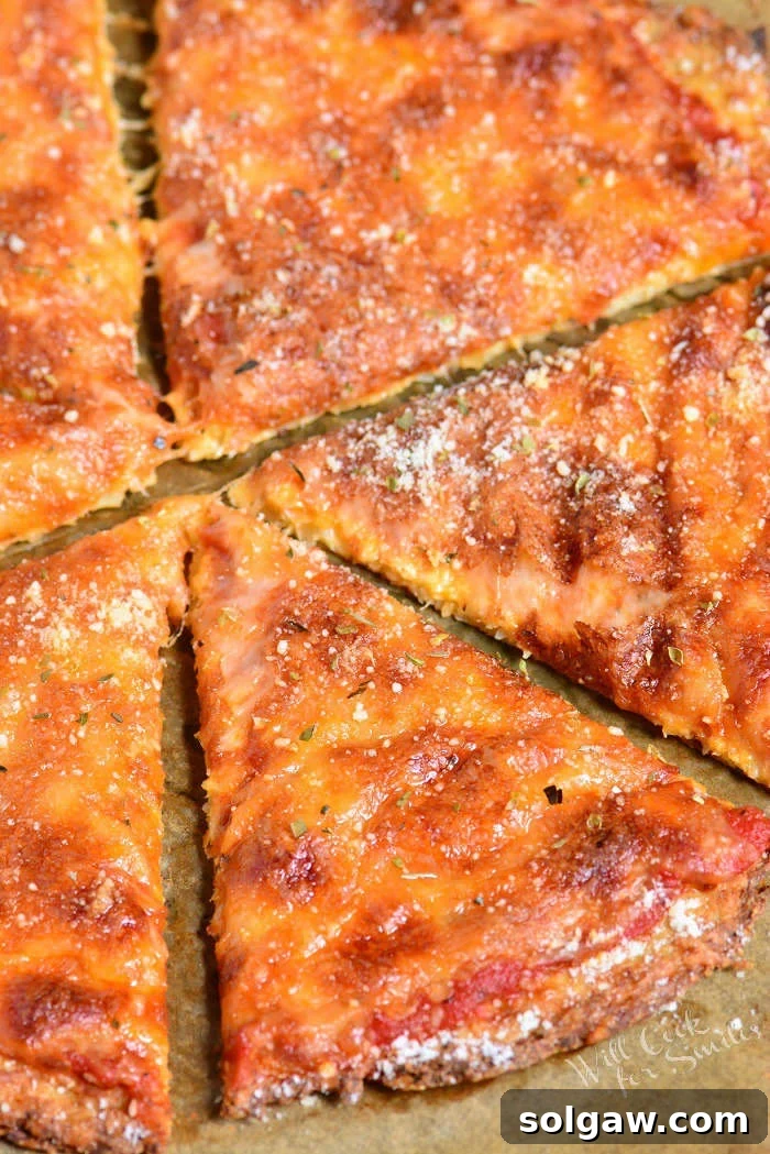 Cauliflower Pizza sliced on parchment paper