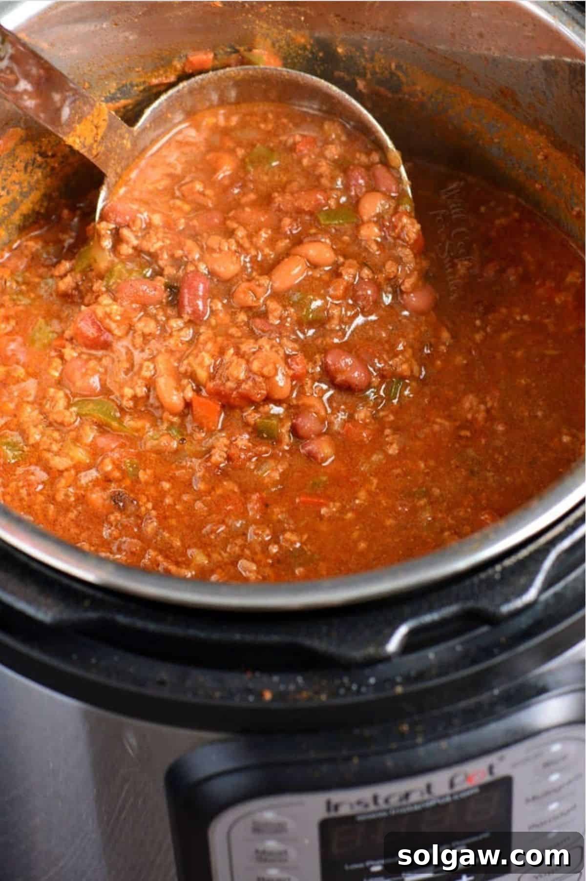 Instant Pot Chili, rich and vibrant, ready to be served, with a ladle scooping a portion, highlighting its hearty texture and perfect consistency.