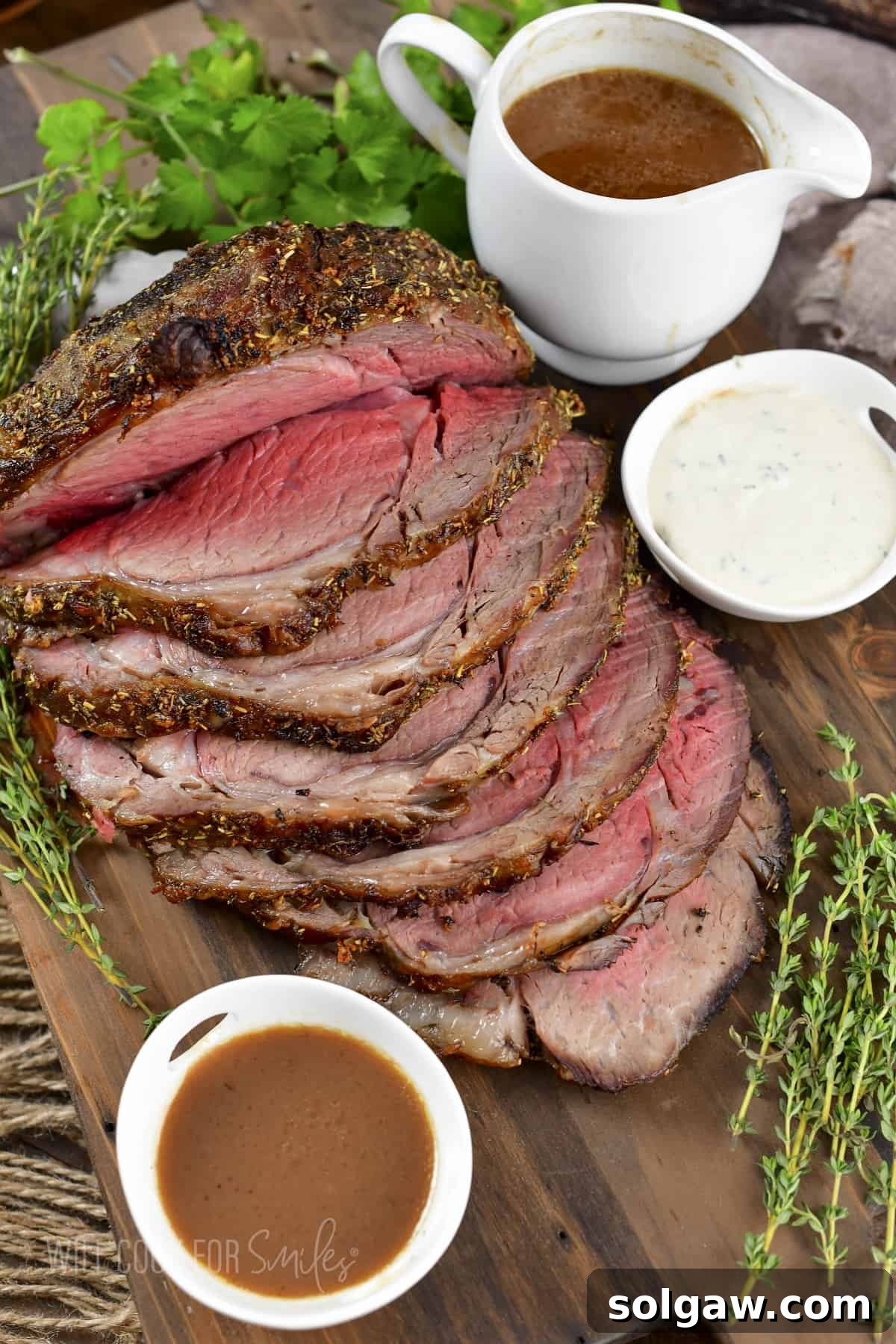 top view of sliced prime rib with au jus and horsey sauce, ready to serve.