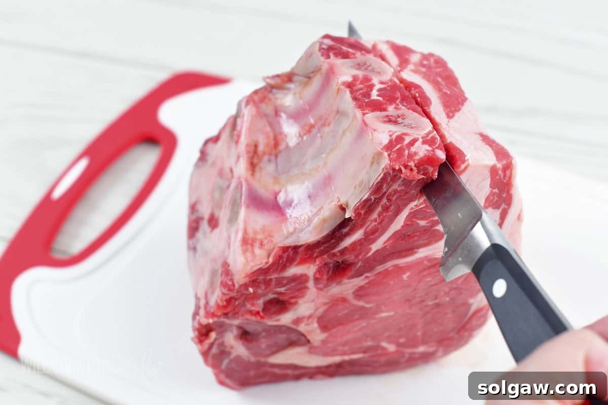 slicing off the rib bone off the prime rib with a knife.