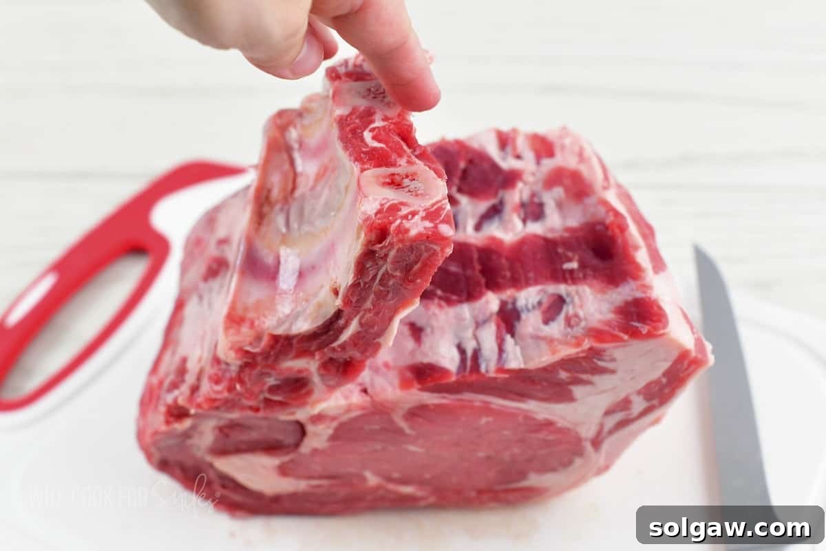 pulling off the rib bones from the prime rib roast after cutting.