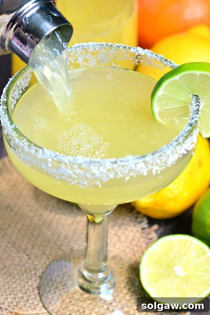 A vibrant margarita cocktail in a classic glass with a salted rim.