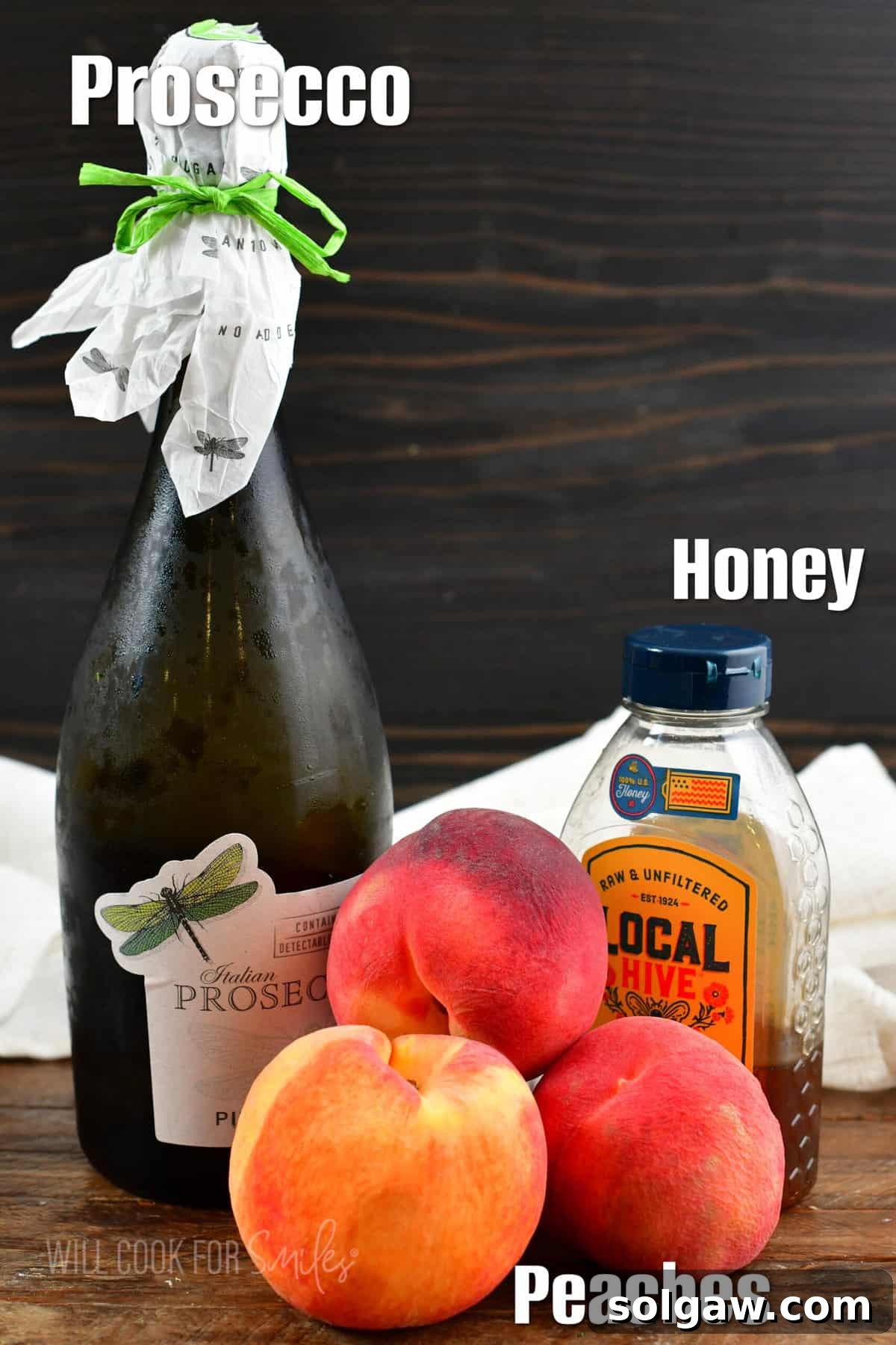 The simple ingredients for peach bellinis are artfully arranged on a rustic wooden surface, highlighting their freshness and appeal.