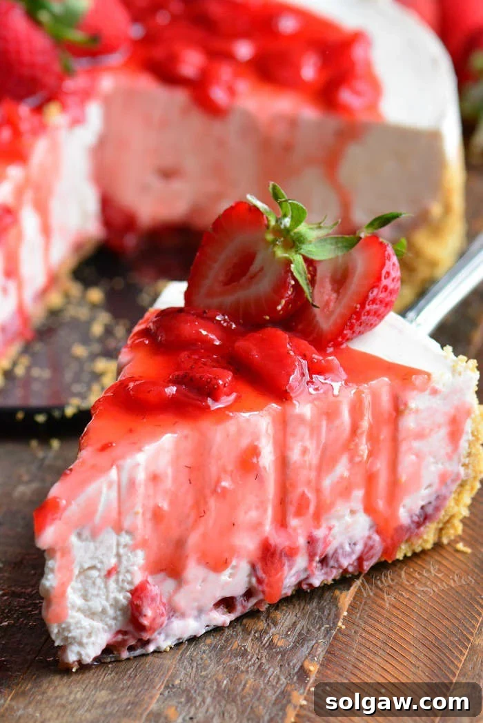 Close-up of a perfect slice of No-Bake Strawberry Cheesecake, showcasing its smooth texture and strawberry layers.