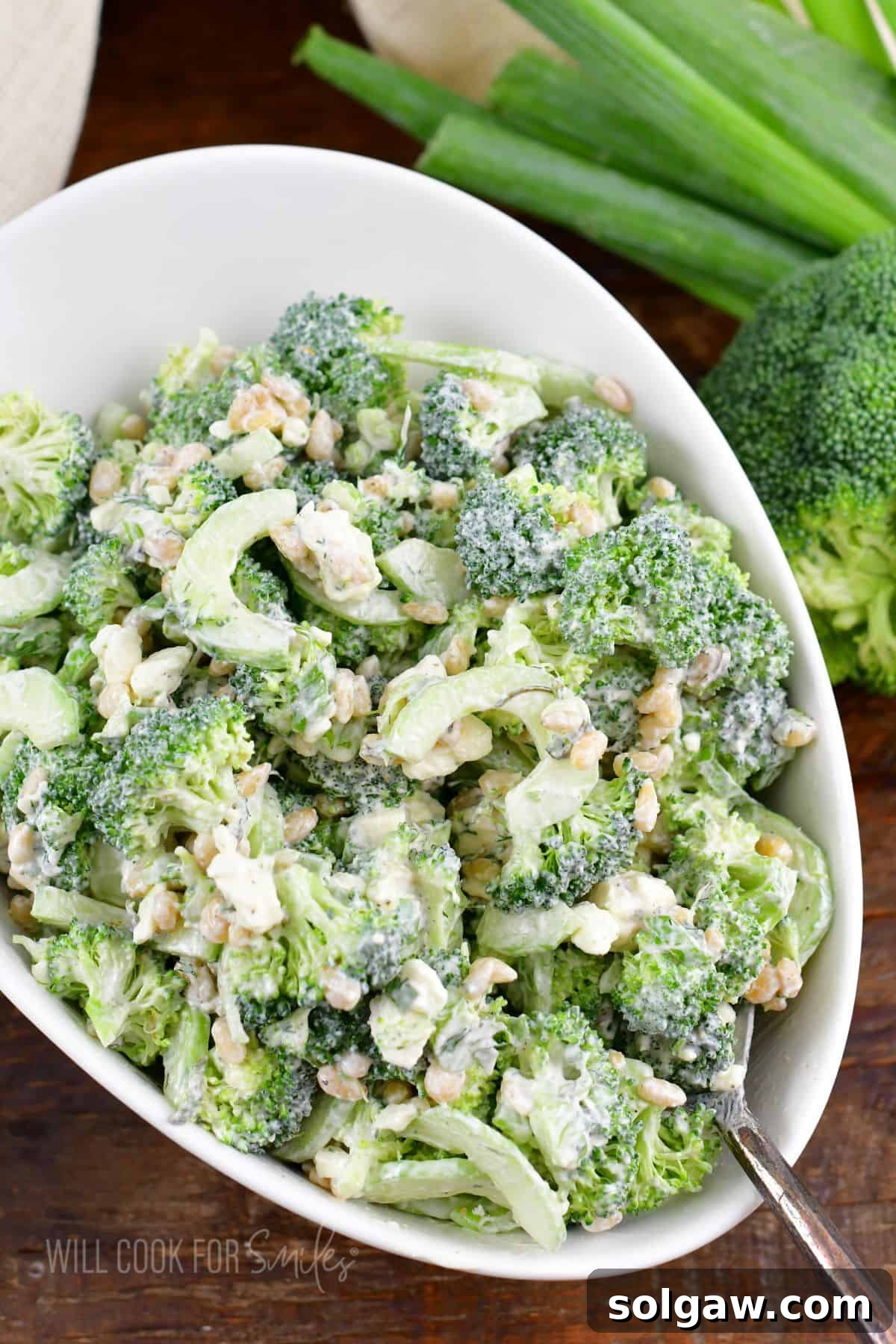 Cucumber broccoli salad is presented in a large white bowl. 