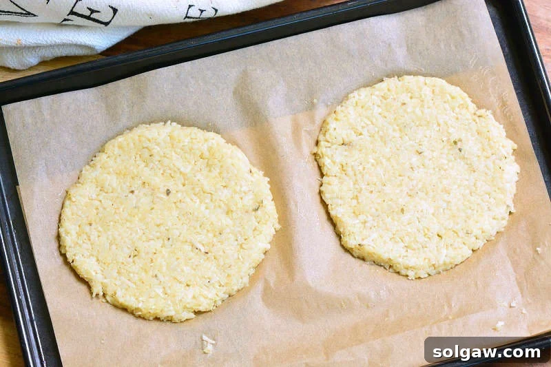 cauliflower grilled cheese pieces uncooked on parchment paper on a baking sheet 