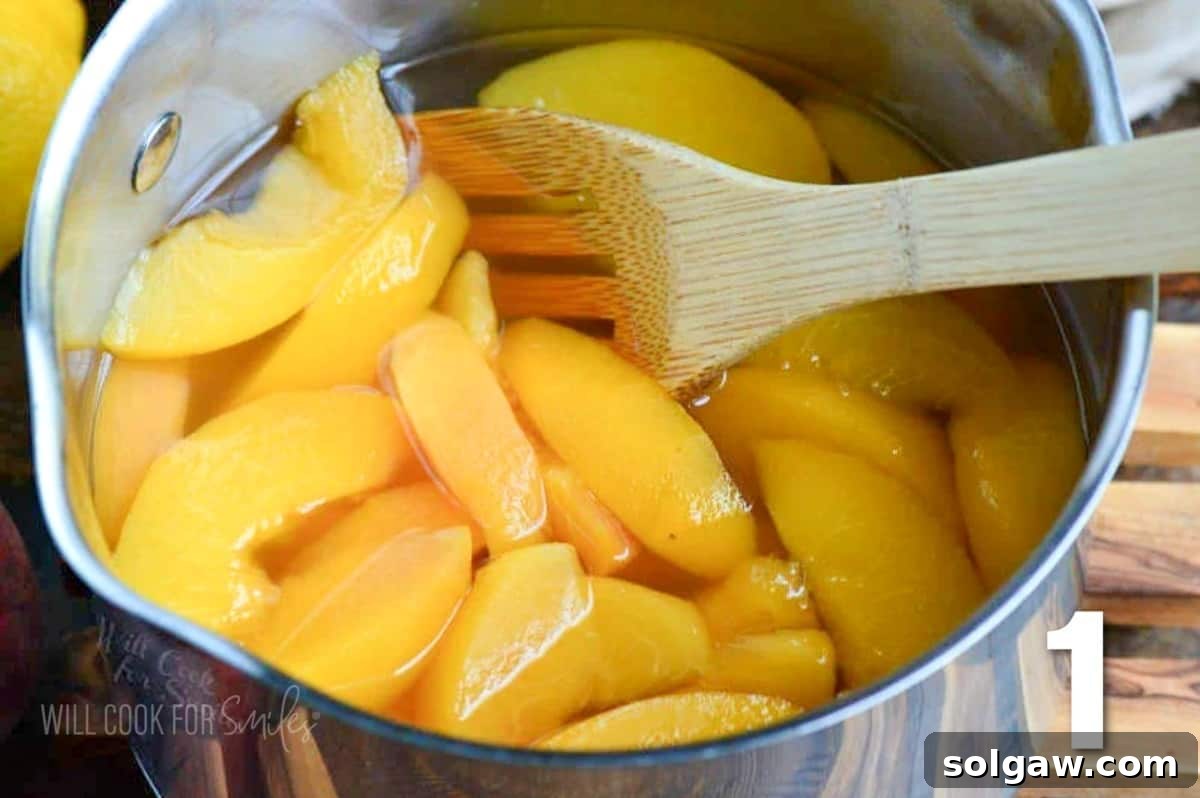 Juicy peach slices simmering gently with sugar and water in a metal pot, creating a fragrant syrup for homemade peach lemonade.