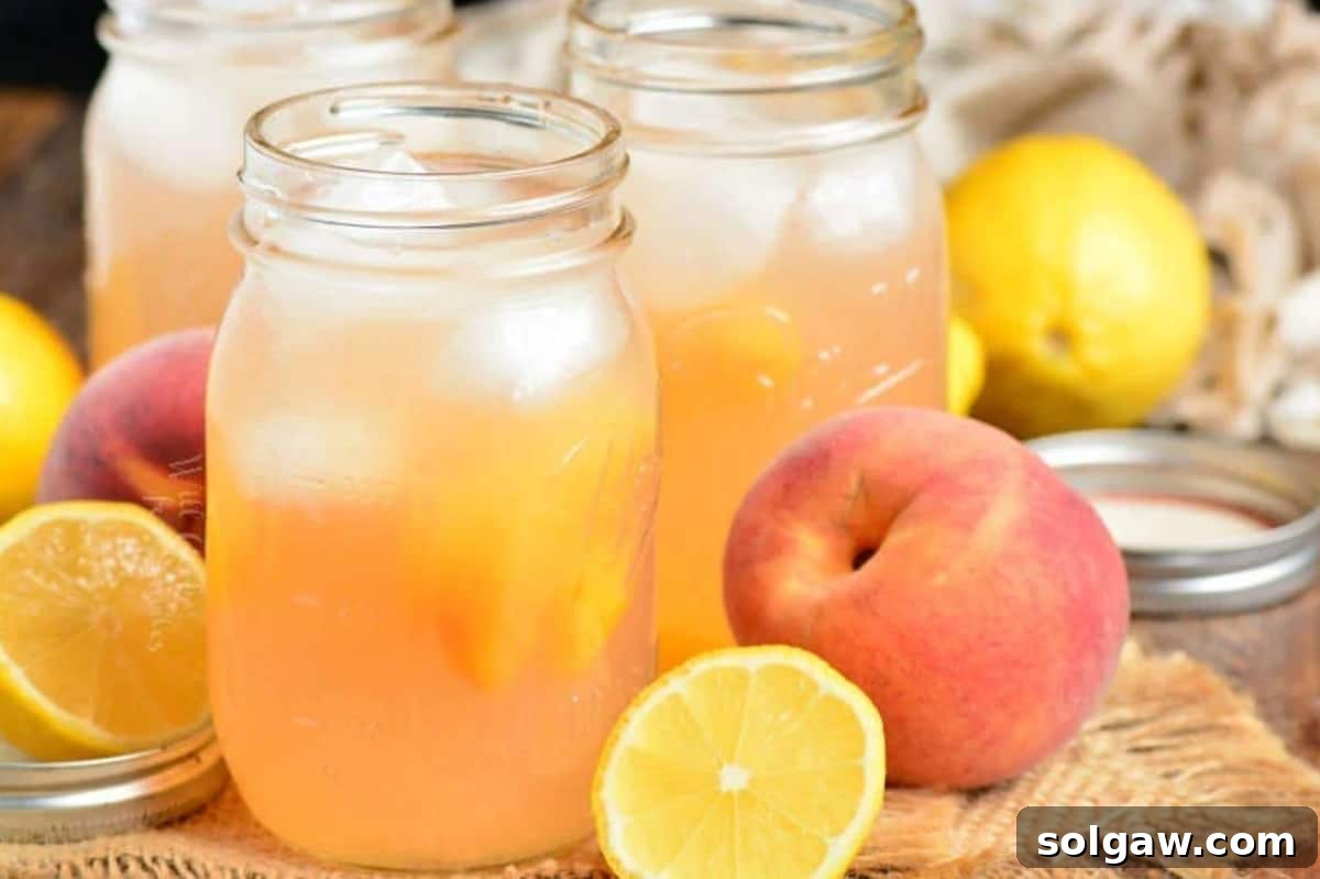 Three mason jars brimming with iced peach lemonade, garnished with fresh peach slices and mint, set against a rustic background, evoking a perfect summer moment.