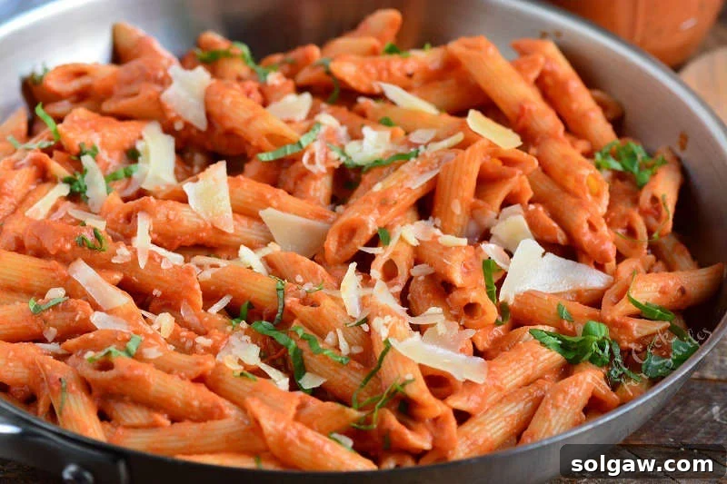 Close-up of penne pasta coated in creamy vodka sauce in a pan, ready to be served