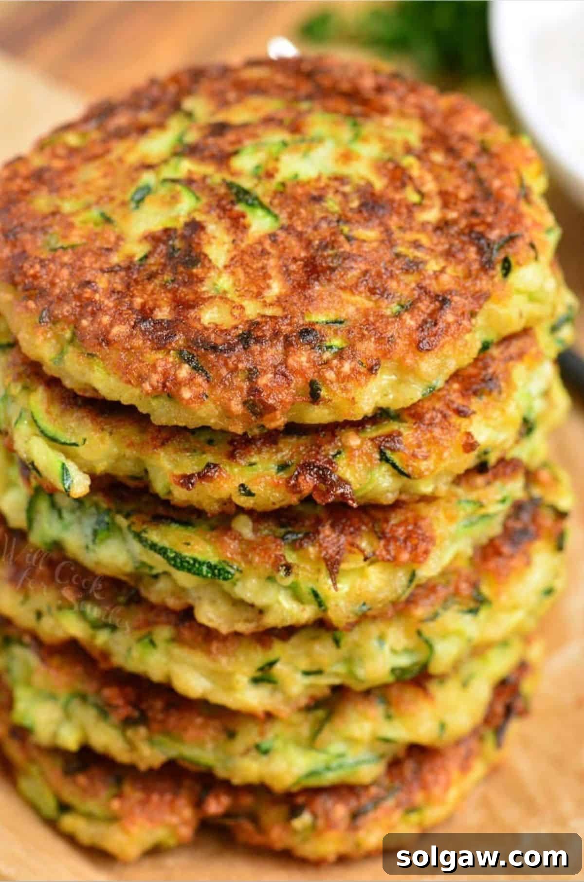 Crispy Zucchini Fritters 2 several zucchini fritters stacked on top of each other.
