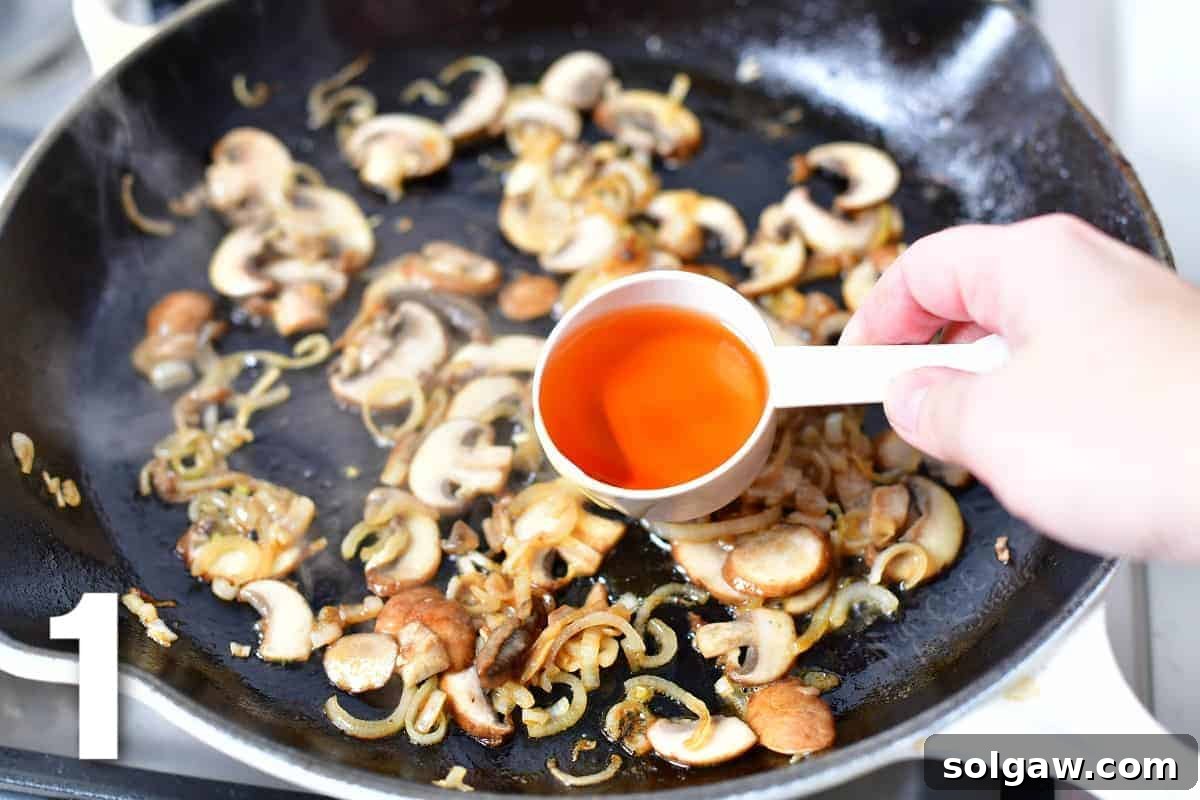 adding cognac to the mushrooms and onions in the pan.