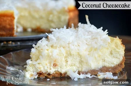 A slice of creamy coconut cheesecake on a elegant glass plate.