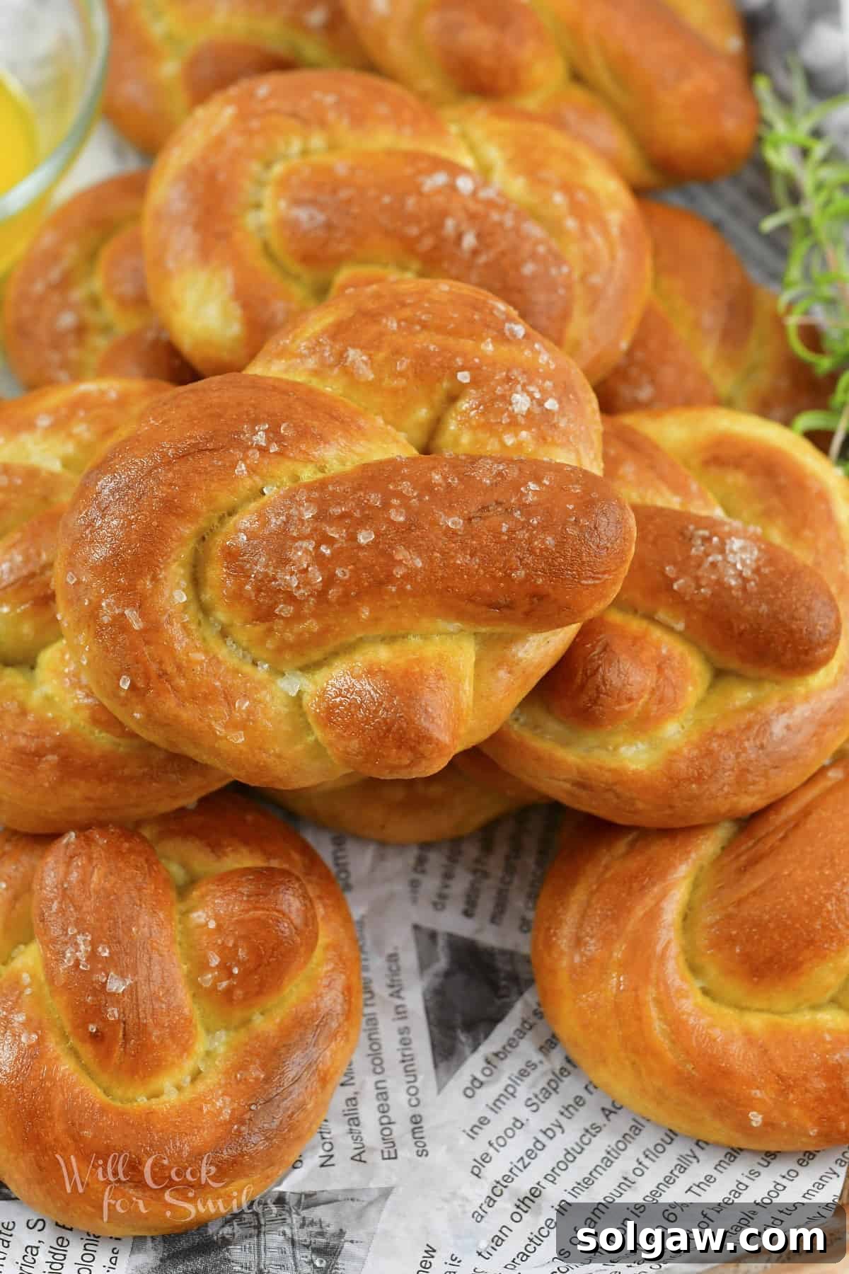 Close-up of golden brown homemade soft pretzels stacked on a serving tray, ready to be enjoyed.