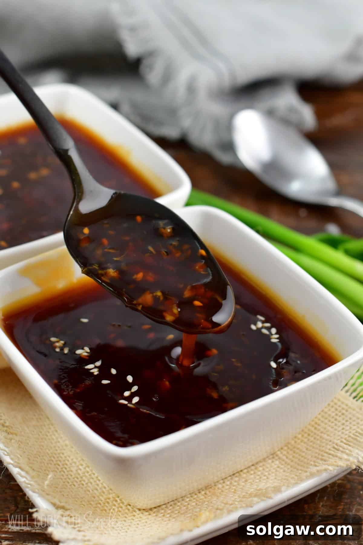A spoon dripping rich, glossy homemade teriyaki sauce, illustrating its perfect consistency and inviting flavor.