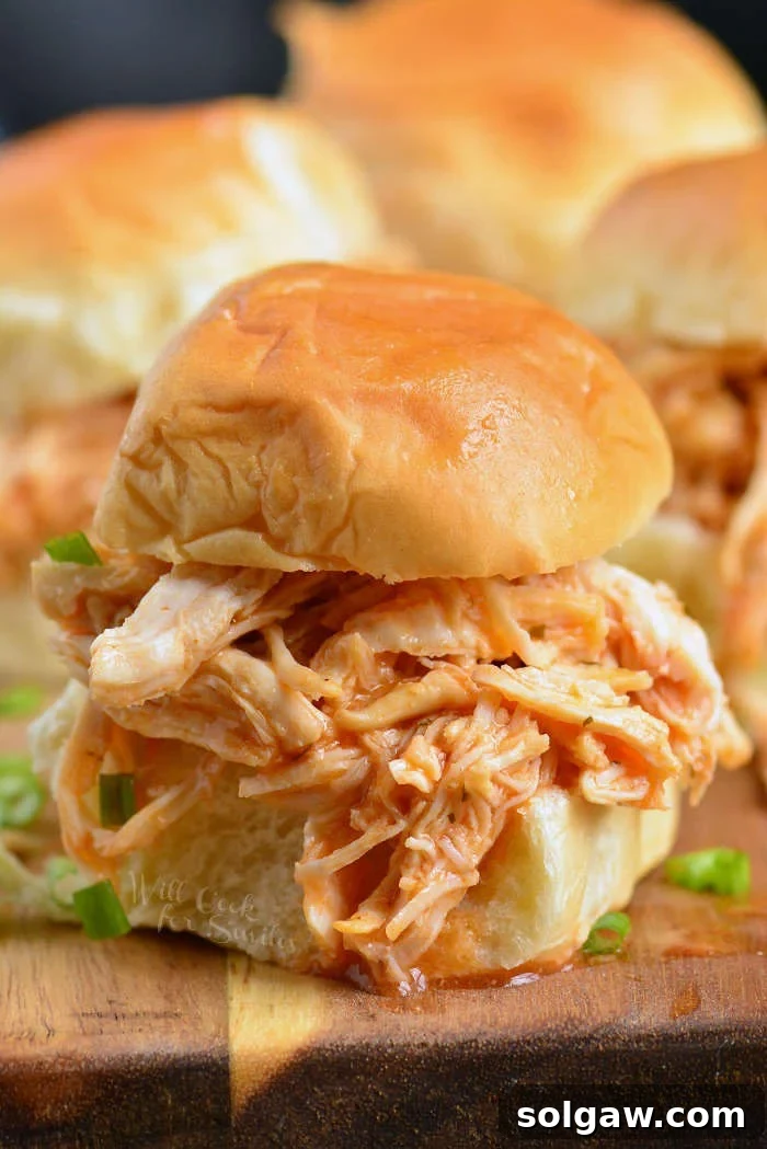 shredded buffalo chicken sandwich on a cutting board 