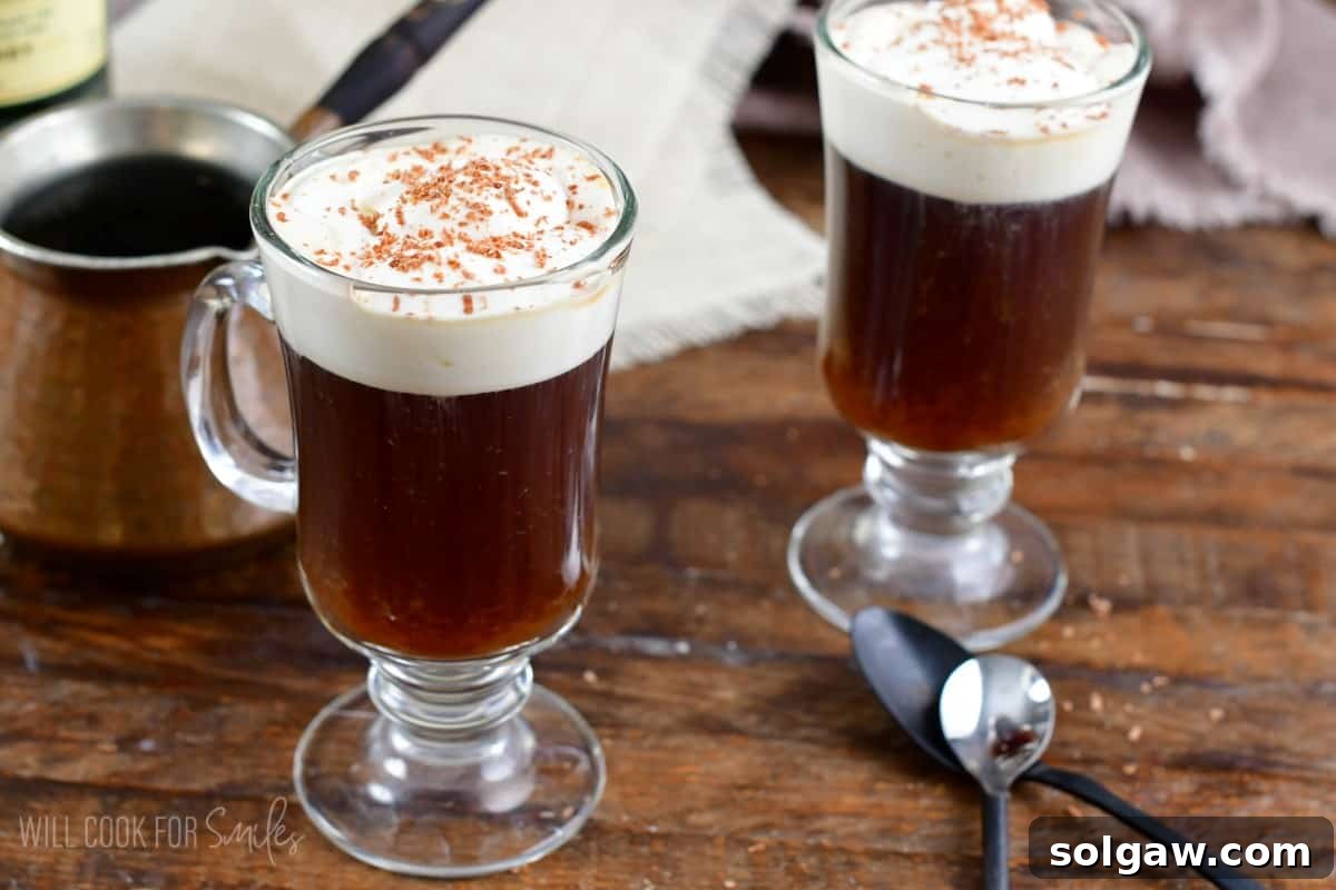 A single glass mug of Irish coffee with a perfectly layered cream top, set on a rustic wooden surface.