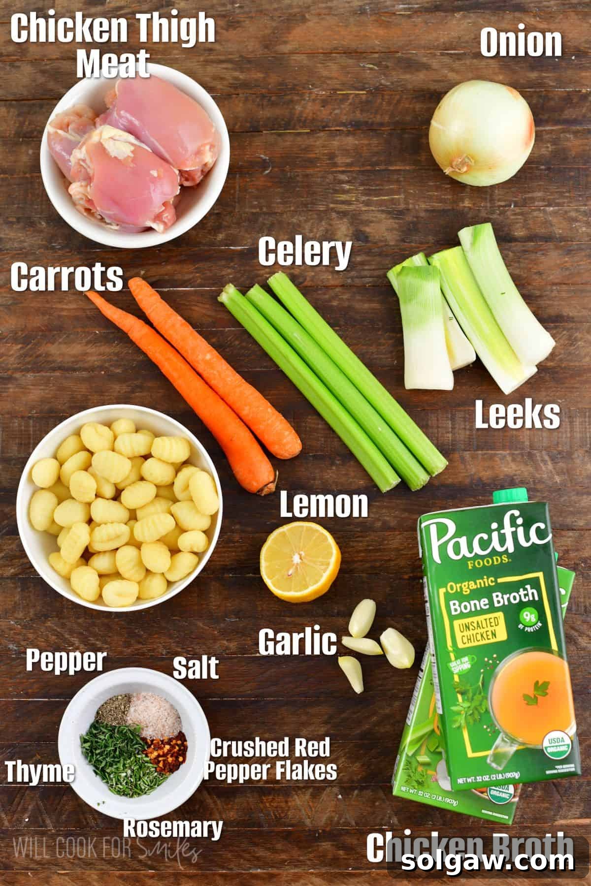 labeled ingredients to make chicken gnocchi soup on wooden board.