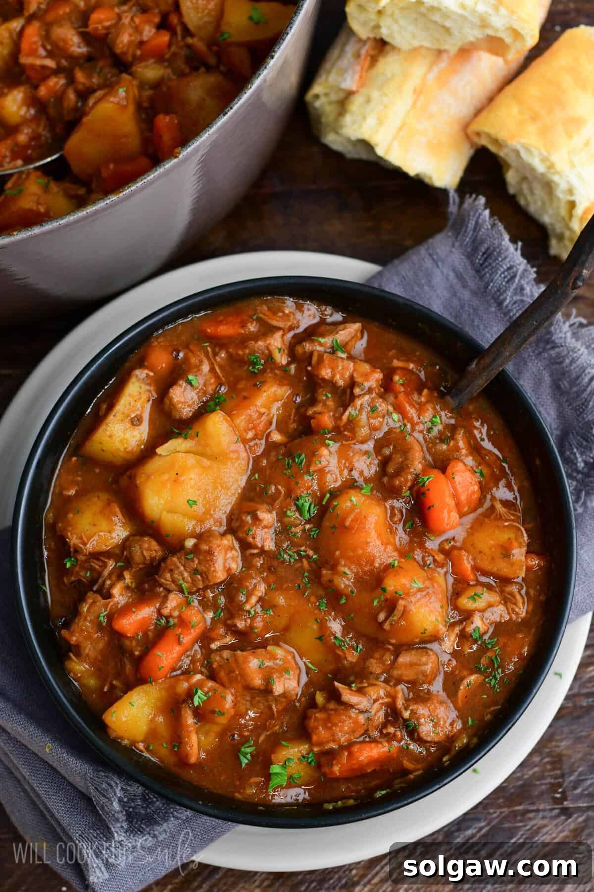 Bowl of hearty Irish lamb stew with tender lamb, potatoes, and carrots in a rich savory broth, garnished with parsley and served with crusty bread.