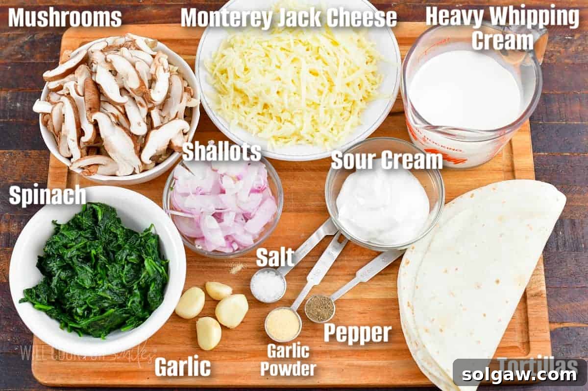 labeled ingredients to make vegetarian enchiladas on a cutting board including spinach, mushrooms, shallots, garlic, cheese, heavy cream, and tortillas.