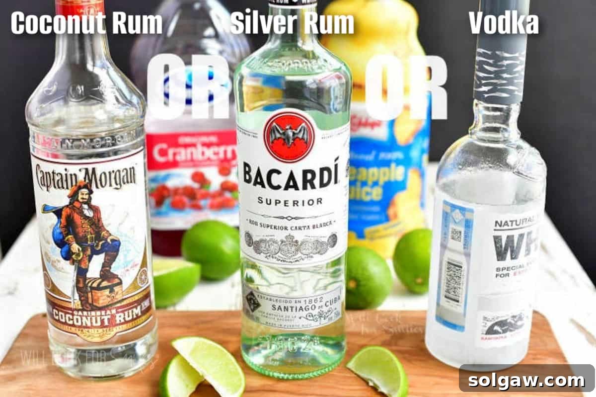 Three distinct bottles of clear liquors: a smooth vodka, a classic light rum, and a sweet coconut rum, awaiting their turn in a Bay Breeze cocktail.