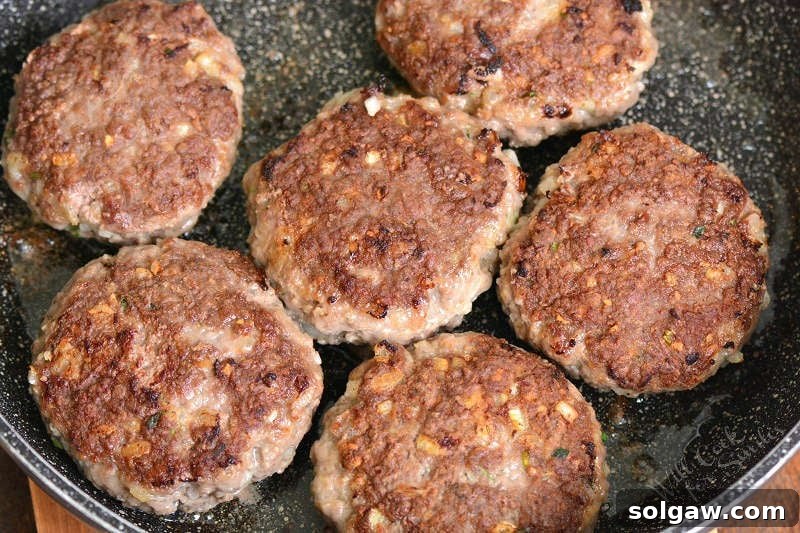 Cooking six Salisbury steak patties in the cooking pan until golden brown sear, showing the delicious crust.