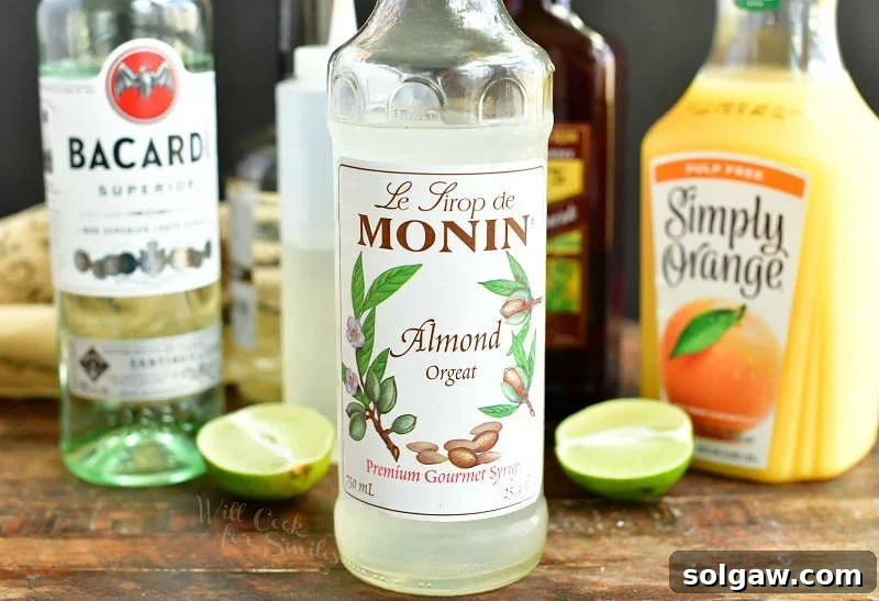 ingredients in bottle lined up with Almond Orgeat syrup bottle being on the foreground